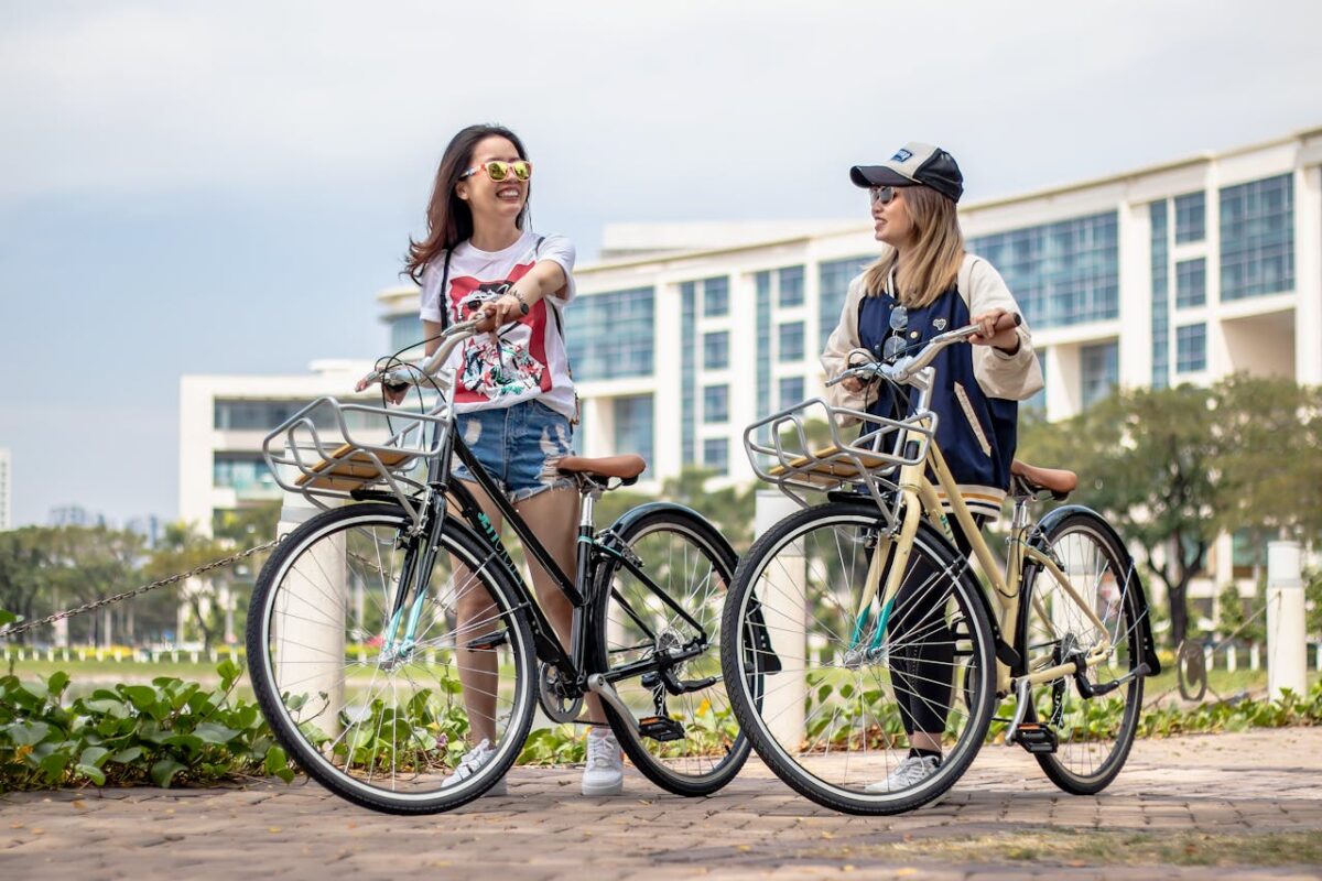 Offres Two women enjoying a sunny day with bicycles in a park in Ho Chi Minh City, Vietnam.